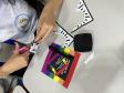 Estudantes produzindo cartazes com mensagens em espanhol em defesa da diversidade