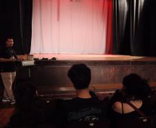 imagens do ministrante da palestra e dos estudantes, em atividade no auditório