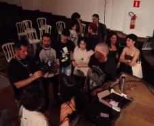 imagens do ministrante da palestra e dos estudantes, em atividade no auditório