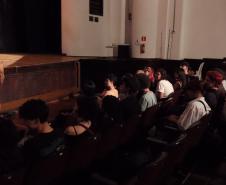 imagens do ministrante da palestra e dos estudantes, em atividade no auditório