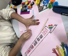 Estudantes produzindo cartazes com mensagens em espanhol em defesa da diversidade