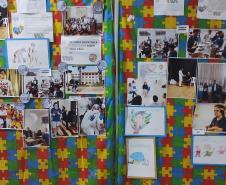 Painéis com fotos e desenhos, de estudantes com TEA