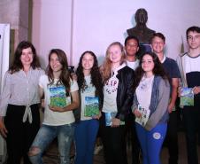 A cerimônia na noite desta quinta-feira (7) reuniu, no hall de entrada do Colégio Estadual do Paraná (CEP), estudantes, professores, poetas e convidados para a entrega do livro Sedução Poética 2019. O exemplar representa a conclusão de mais uma edição do projeto de linguagem coordenado pelo setor de Língua Portuguesa do Colégio, com objetivos de envolver e incentivar a Comunidade Escolar a produzir, declamar e publicar textos e ilustrações relacionados com a poesia.