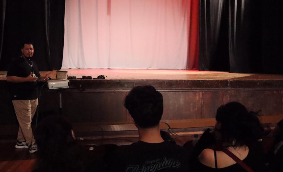 imagens do ministrante da palestra e dos estudantes, em atividade no auditório