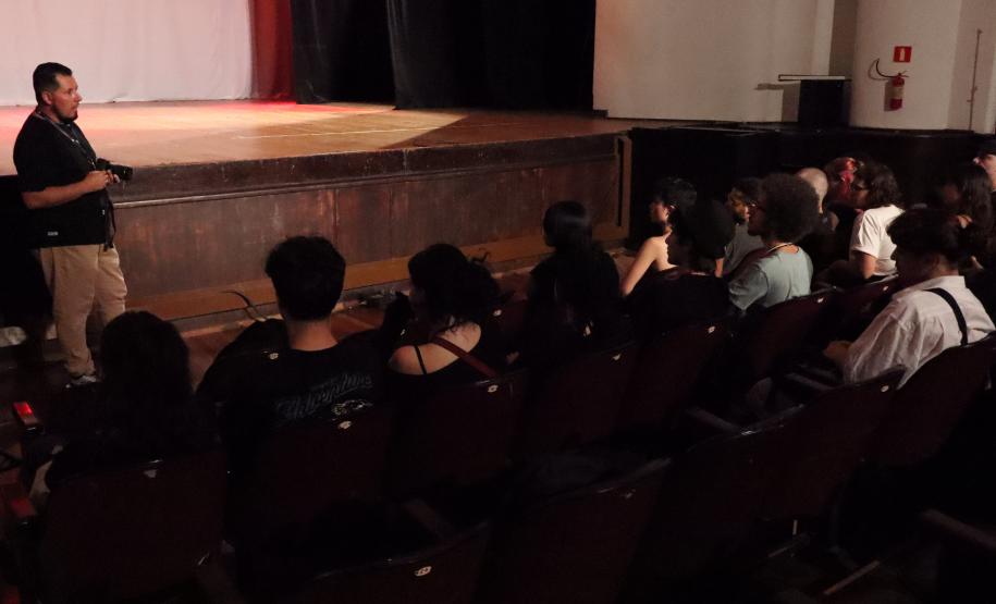 imagens do ministrante da palestra e dos estudantes, em atividade no auditório