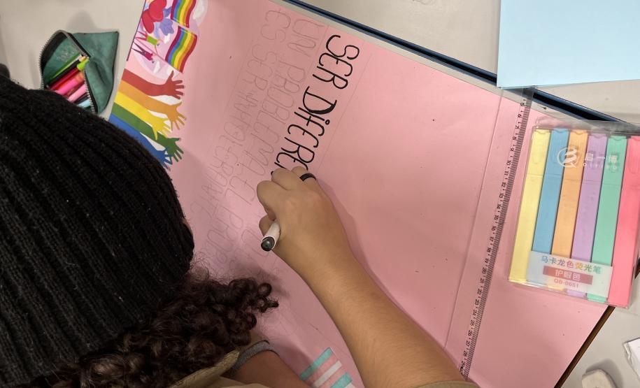 Estudantes produzindo cartazes com mensagens em espanhol em defesa da diversidade