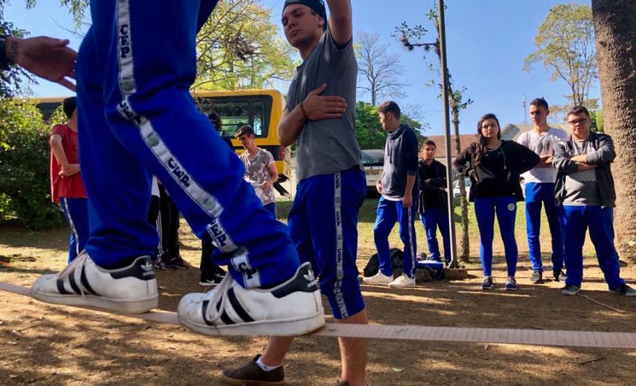 slackline 5 Estudantes do Colégio Estadual do Paraná (CEP) estão experimentando o slackline nas aulas curriculares de Educação Física. A missão é andar sobre uma fita esticada, suspensa do solo em aproximadamente um metro de altura, permitindo assim que o aluno e aluna pisem firme para avançar de um lado para outro sem cair e até possibilitar a execução de algumas acrobacias.