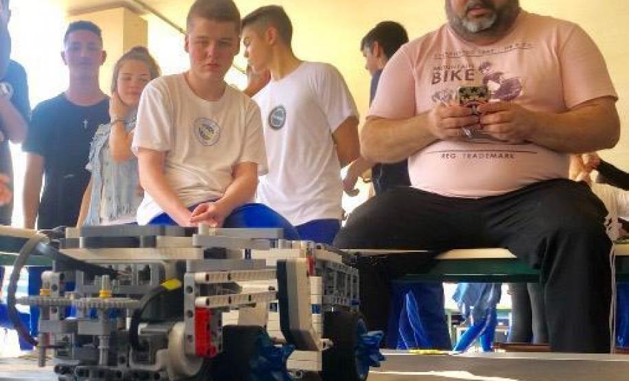 Essa é mais uma disputa de SumoBot, um confronto entre robôs programados por estudantes que participam das aulas de laboratório de Robótica no Colégio Estadual do Paraná (CEP). Vence o protótipo que consegue empurrar o adversário para fora da linha que delimita o espaço reservado para o enfrentamento dos robôs.