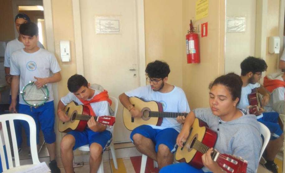 Homenagem 1 Na sexta-feira (11), em algumas unidades de atendimento, os estudantes cantaram e tocaram músicas do repertório nacional, sempre acompanhados pelo professor Jonas Nascimento, no violão.