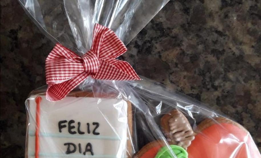 Homenagem 8 Outros estudantes preferiram fazer suas homenagens de uma maneira mais discreta. A professora de Arte Andreia Schultz, por exemplo, ganhou de um dos seus aprendizes um pacote com bolachas alemãs decoradas, uma delas com a mensagem "Feliz Dia Prof" e a outra no formato de maça. “Um pequeno agrado, mas que demostra nos detalhes o imenso carinho que compartilha com a gente”, disse a professora, que não escondeu sua alegria pelo mimo recebido.