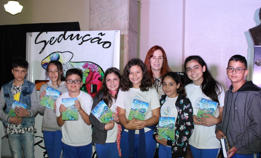 A cerimônia na noite desta quinta-feira (7) reuniu, no hall de entrada do Colégio Estadual do Paraná (CEP), estudantes, professores, poetas e convidados para a entrega do livro Sedução Poética 2019. O exemplar representa a conclusão de mais uma edição do projeto de linguagem coordenado pelo setor de Língua Portuguesa do Colégio, com objetivos de envolver e incentivar a Comunidade Escolar a produzir, declamar e publicar textos e ilustrações relacionados com a poesia.