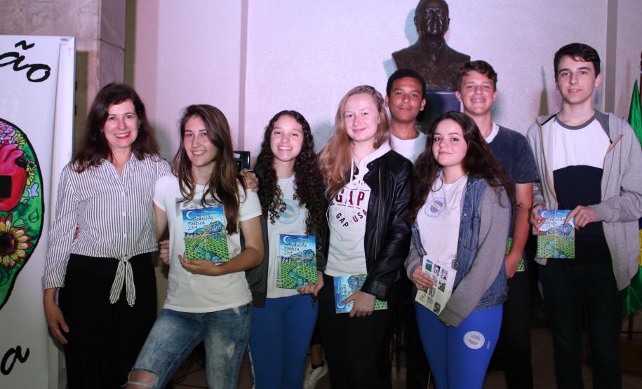 A cerimônia na noite desta quinta-feira (7) reuniu, no hall de entrada do Colégio Estadual do Paraná (CEP), estudantes, professores, poetas e convidados para a entrega do livro Sedução Poética 2019. O exemplar representa a conclusão de mais uma edição do projeto de linguagem coordenado pelo setor de Língua Portuguesa do Colégio, com objetivos de envolver e incentivar a Comunidade Escolar a produzir, declamar e publicar textos e ilustrações relacionados com a poesia.