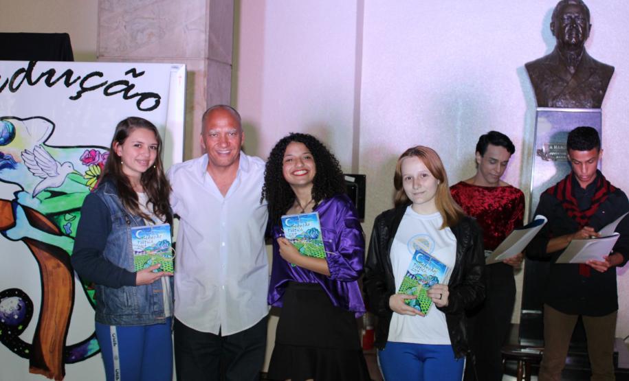 A cerimônia na noite desta quinta-feira (7) reuniu, no hall de entrada do Colégio Estadual do Paraná (CEP), estudantes, professores, poetas e convidados para a entrega do livro Sedução Poética 2019. O exemplar representa a conclusão de mais uma edição do projeto de linguagem coordenado pelo setor de Língua Portuguesa do Colégio, com objetivos de envolver e incentivar a Comunidade Escolar a produzir, declamar e publicar textos e ilustrações relacionados com a poesia.